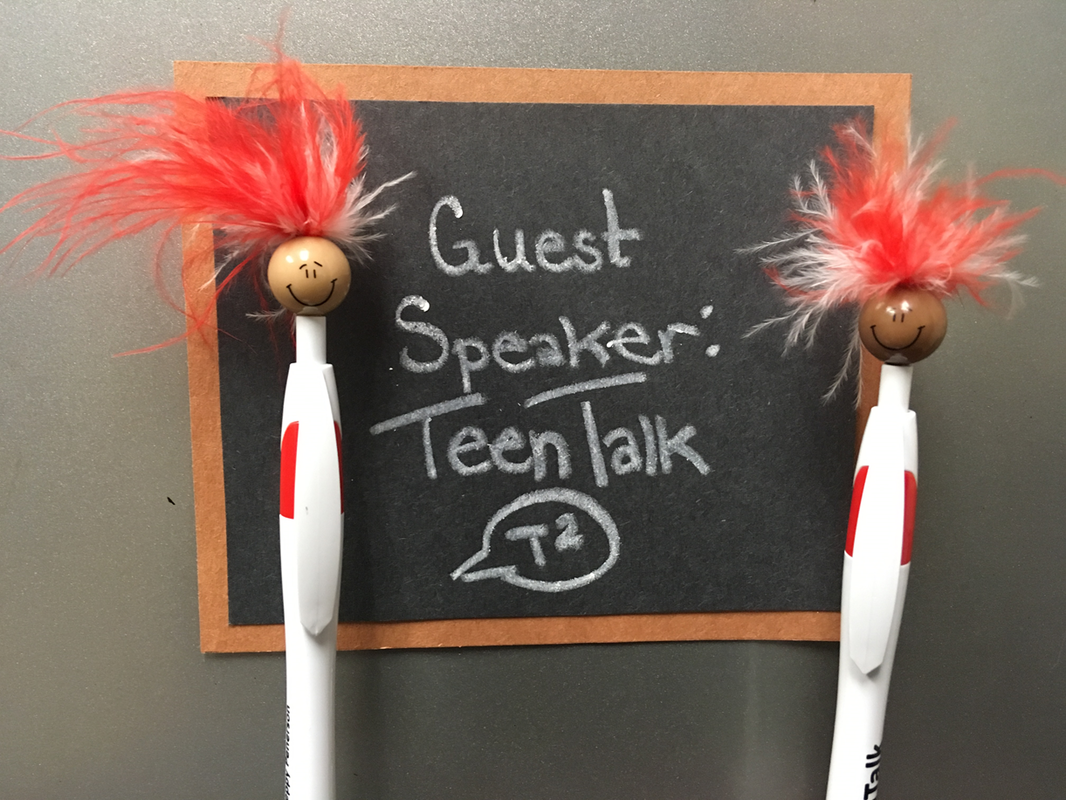 Two Peppys standing in front of a chalkboard that reads Guest Speaker: TeenTalk with the TeenTalk logo underneath